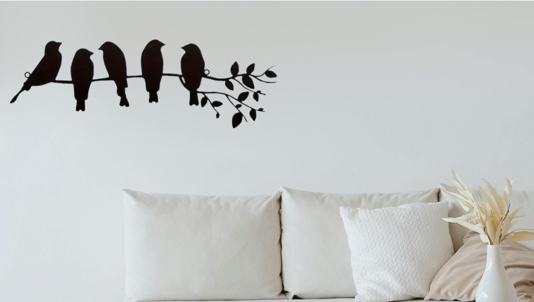 Minimalist living room with beige sofa, textured white pillow, dried foliage in vase, and black bird silhouette wall art