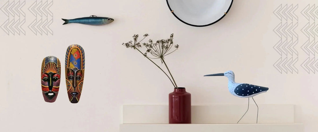 Handcrafted home decor with colorful tribal masks, wooden bird sculpture, dried flowers in red vase, and round wall mirror