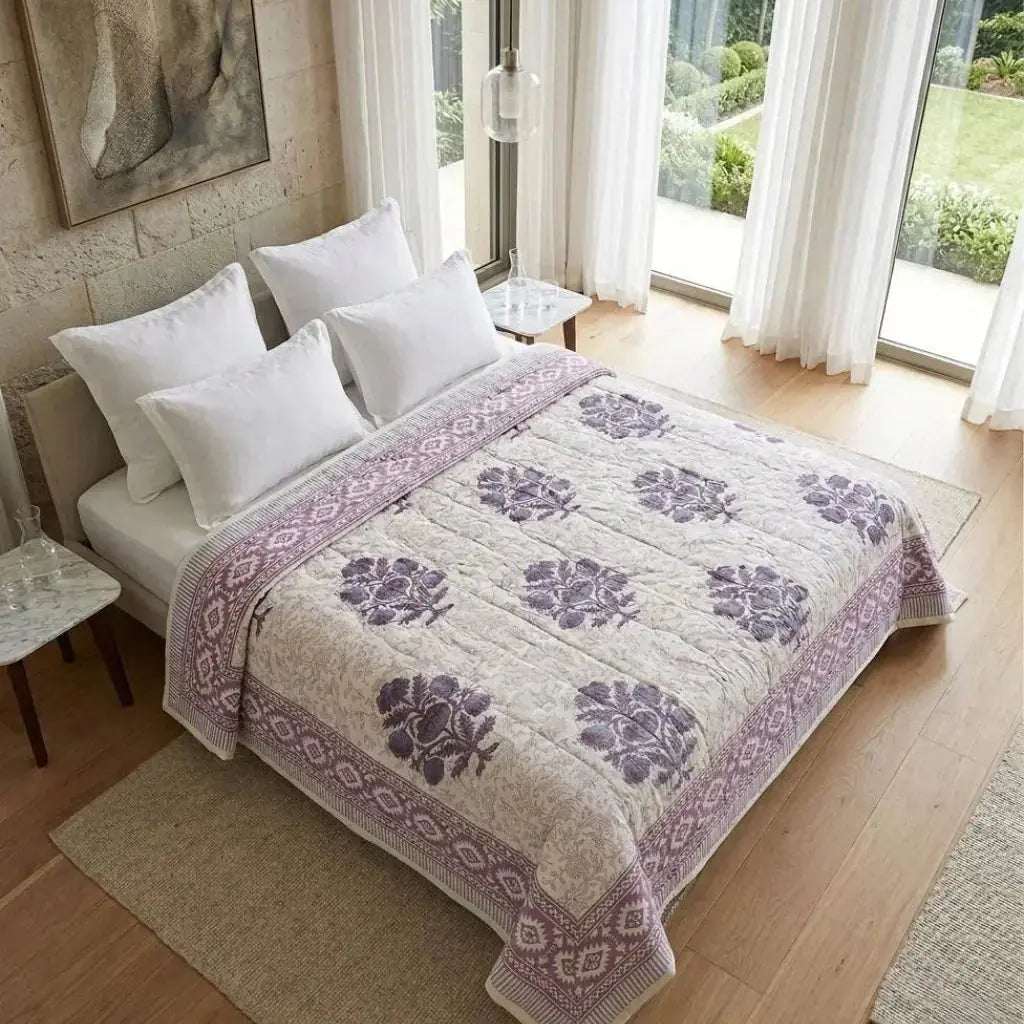 Bed with a floral patterned quilt in a bright bedroom [[SKU:HOA-IND-CM-001]]