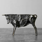 Textured dark metallic bull statue with rugged cast-metal finish and angular limbs for home decor