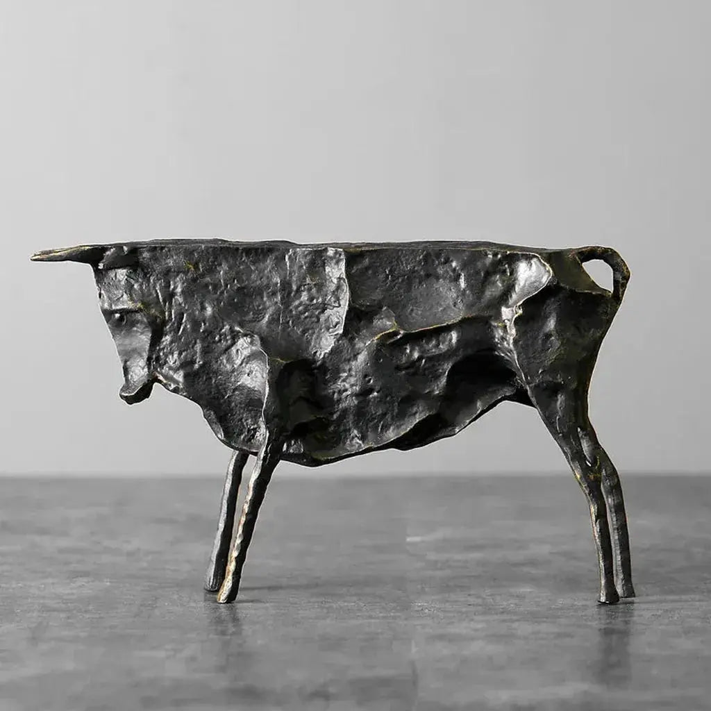 Textured dark metallic bull statue with rugged cast-metal finish and angular limbs for home decor