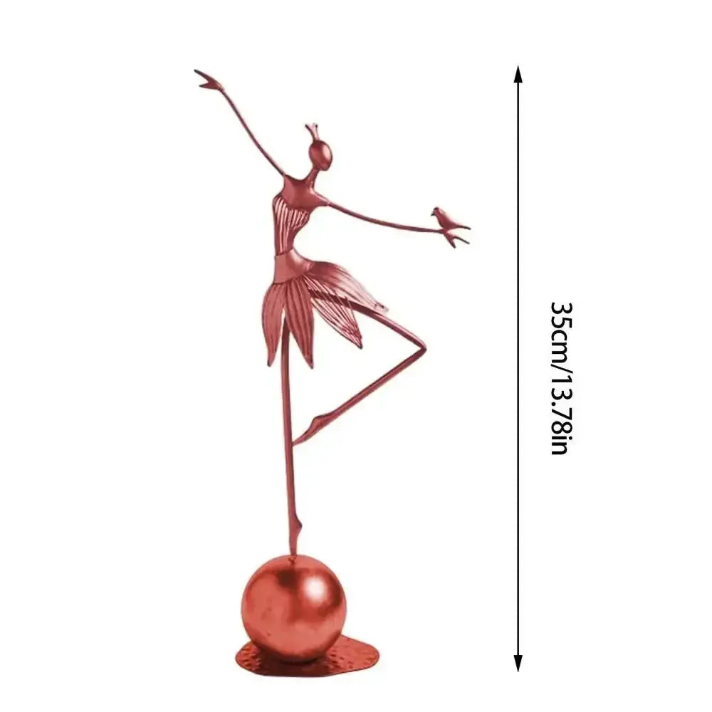 Rose-gold abstract dancing ballerina metal sculpture balancing on one leg with a bird on her arm atop a spherical base