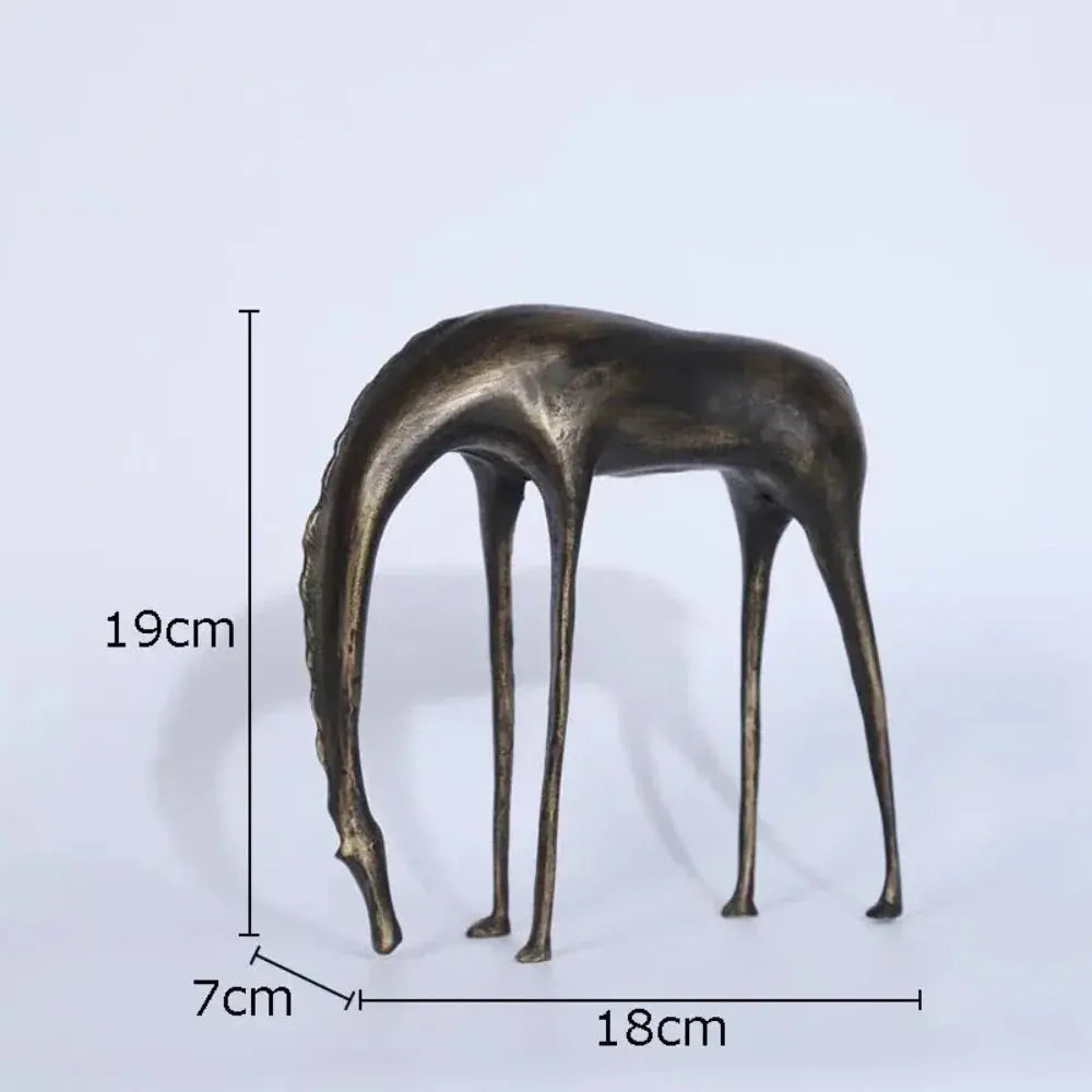 Bronze-colored abstract giraffe sculpture with slender legs and elongated neck on a flat surface for rustic decor