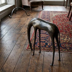 A sleek dark bronze metal horse sculpture with slender legs and elongated neck for rustic living room decor