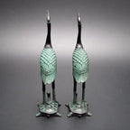 Pair of bronze-colored antique crane figurines with green patina standing on detailed turtle statue bases for luxury decor