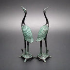Pair of bronze-colored antique crane figurines with green patina standing on detailed turtle statue bases for décor