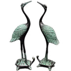 Bronze-colored antique crane figurines with green patina standing on turtle statue set bases for luxury decor