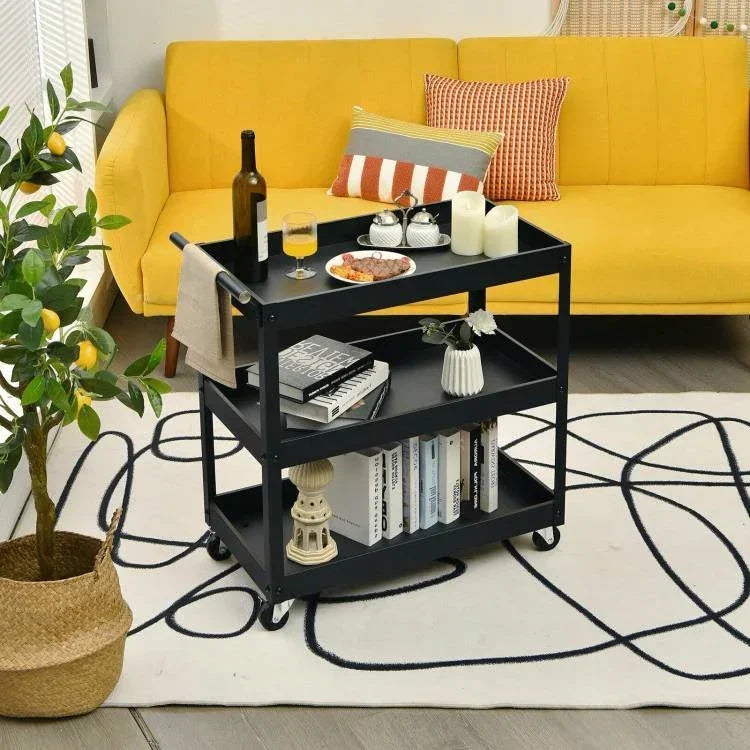 Black serving cart with items in front of a yellow couch