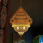 Decorative gold lantern hanging against a dark background with intricate patterns.