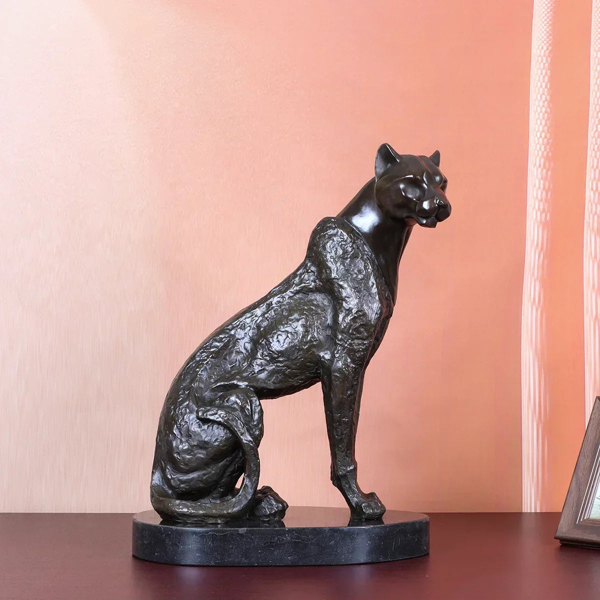 Bronze cheetah decorative sculpture featuring an intricately textured seated panther on a dark marble base for living rooms