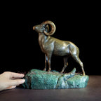 Bronze ram decorative sculpture with detailed curved horns on a textured rocky base for living room tabletop decor