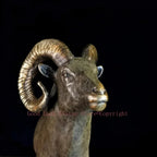 Bronze ram decorative sculpture with intricately detailed spiraling horns and textured rocky base for living room decor