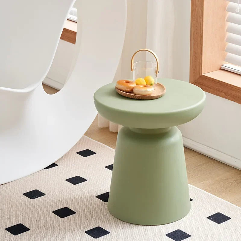Compact size mint green ceramic coffee table with smooth rounded top and tapered cylindrical base for living room use