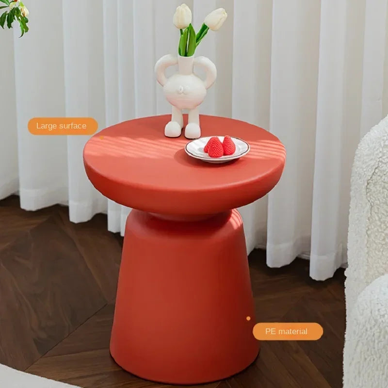 Vibrant orange pe material coffee table with smooth rounded top and compact size ideal for living room use
