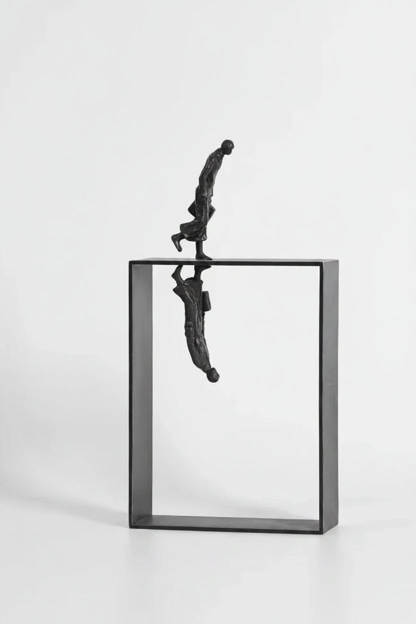 Black metallic dancer statue balancing on open rectangular frame with mirrored reflection for art lovers and ballet enthusiasts