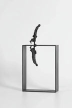 Black metallic dancer statue balancing on open rectangular frame with mirrored reflection for art lovers and ballet enthusiasts