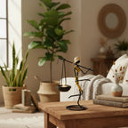 Decorative black and yellow wire candle holder figure wearing straw hat balancing lit candle for home decor warmth