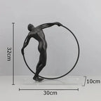 Black matte metal desk statue of a nude male figure holding a circular hoop for modern home office decor