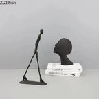 Black matte-finished modern metal desk statue featuring a slender walking figure and stylized head bust for home office