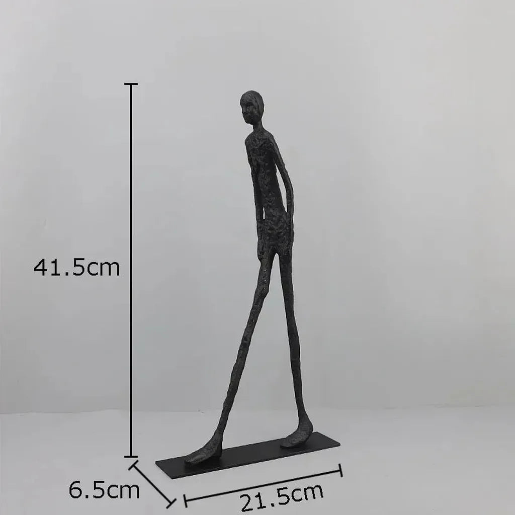 A sleek dark gray metallic desk statue with a slender humanoid figure in modern design for home office use