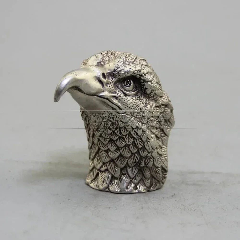 Silver eagle head figurine with detailed feather texture and polished beak in a decorative bronze eagle sculpture