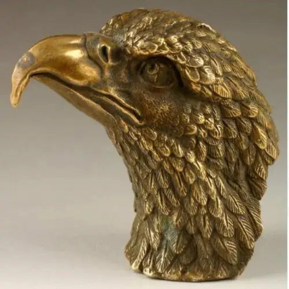 Golden brass eagle sculpture decorative with intricately detailed feathers and sharp curved beak in bronze material