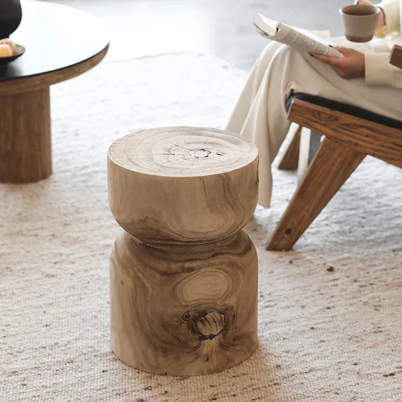 Rustic light-toned round wooden small end table with natural wood grain and knots for living room use