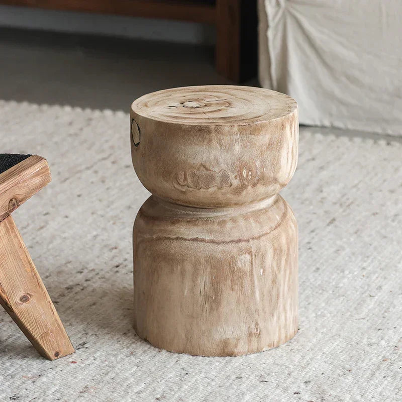 Rustic light-colored round wooden small end table with a rounded top and cylindrical base for living room use