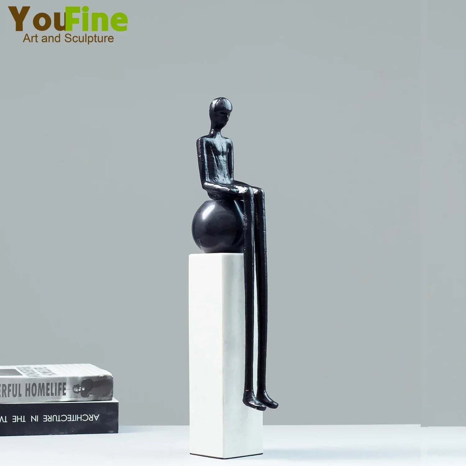 Black minimalist luxury metal small figurine of a seated figure with elongated limbs on a glossy sphere pedestal