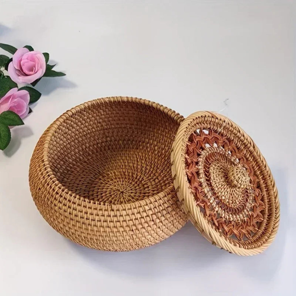 Woven basket with a lid on a white background with pink flowers.