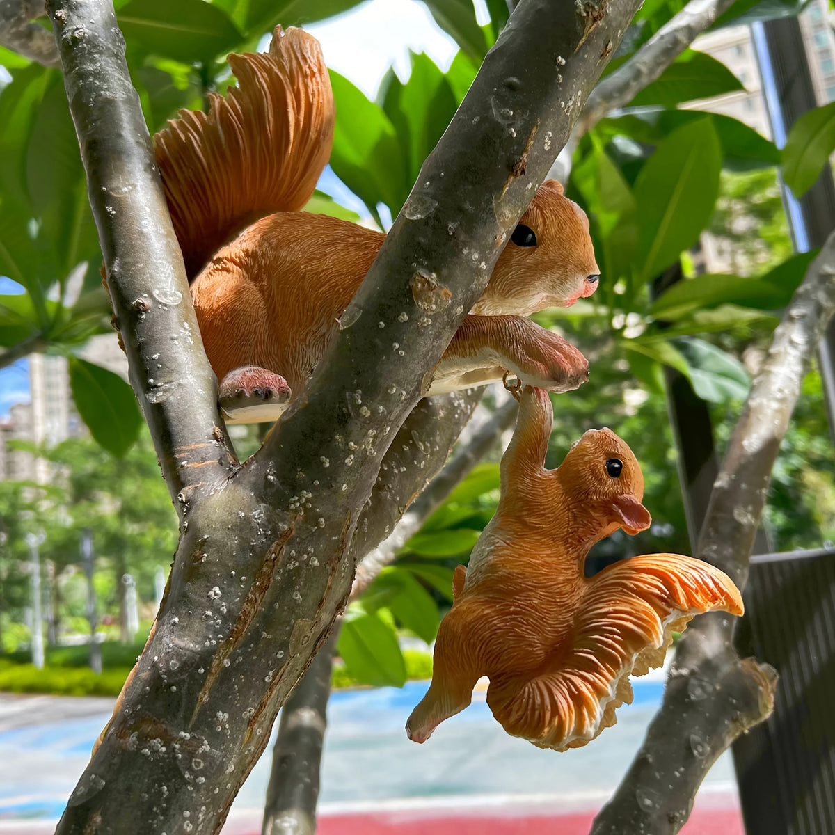 Realistic mother squirrel holding a baby squirrel climbing a tree branch garden ornament [[SKU:HOA-GSC-011]]