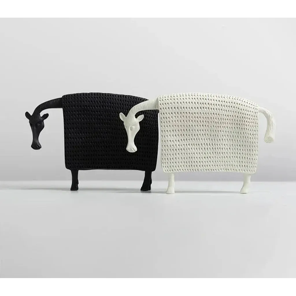 Black and white textured resin sheep figurines with stylized heads and legs alongside elegant ceramic horse figurine
