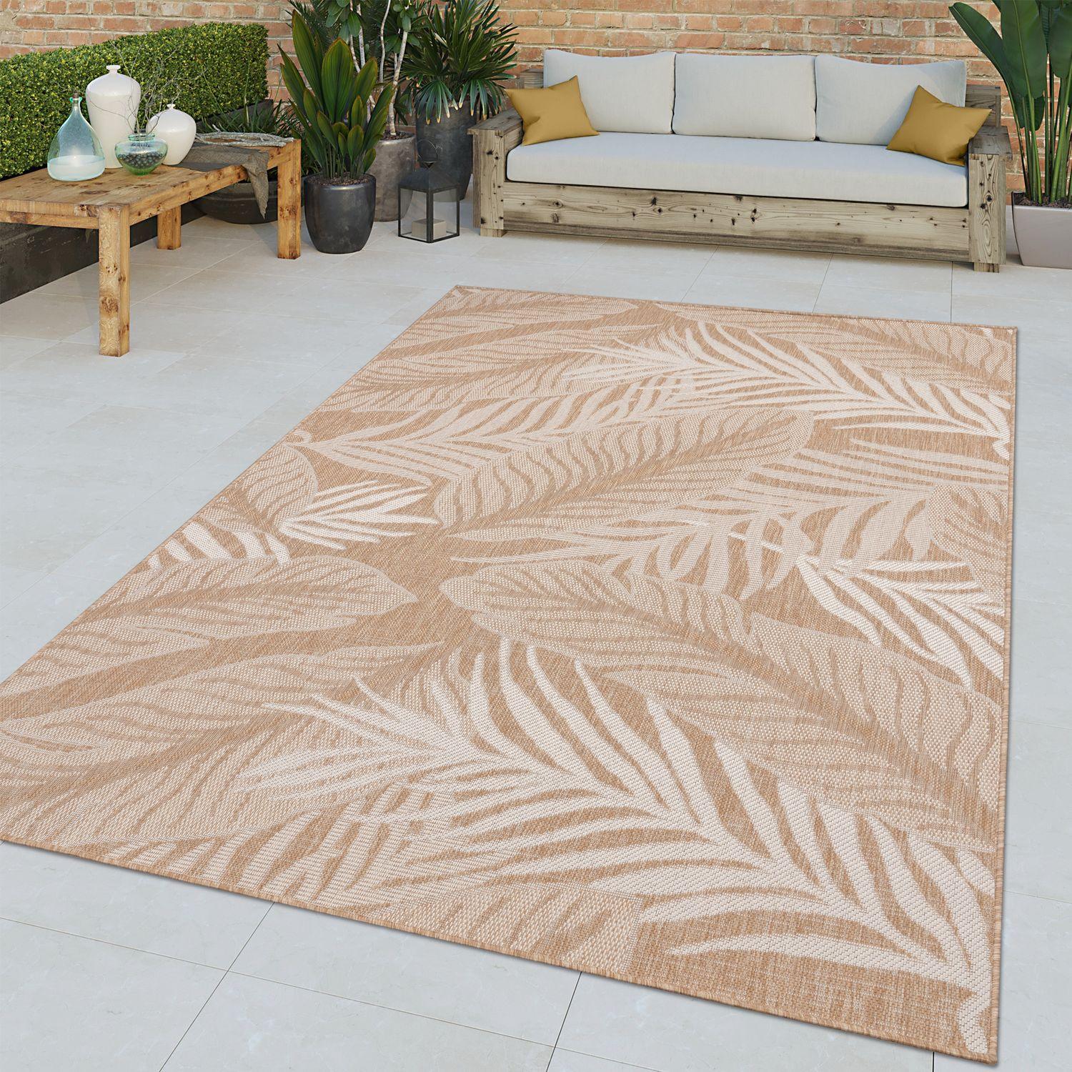 Beige and white tropical leaf pattern indoor outdoor rug on a modern patio setting