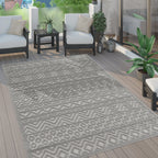 Grey boho indoor outdoor rug with high-low geometric pattern on a wooden patio deck