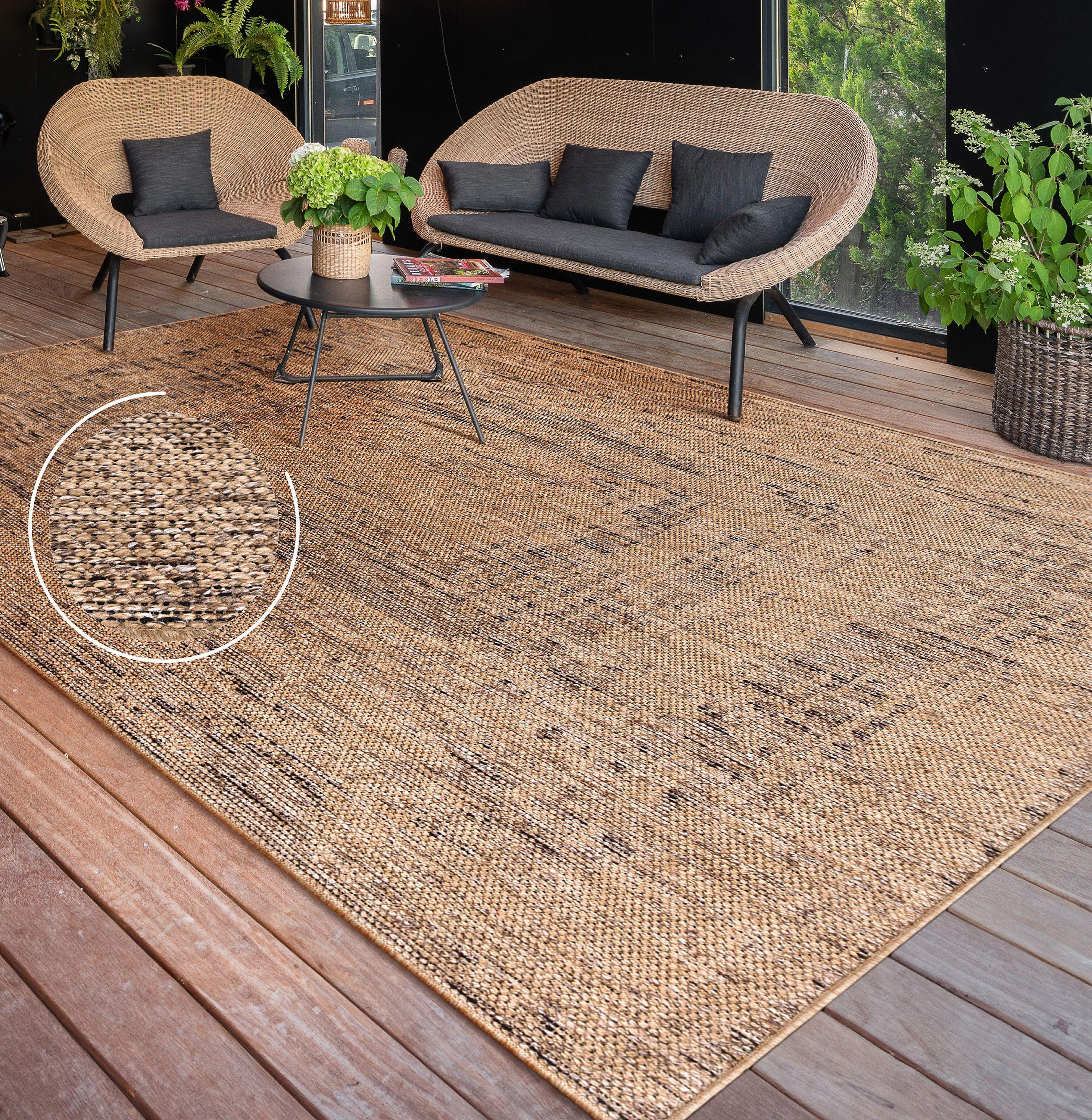 Rico braided look indoor and outdoor rug with a natural tan and black textured weave on a wooden patio deck.