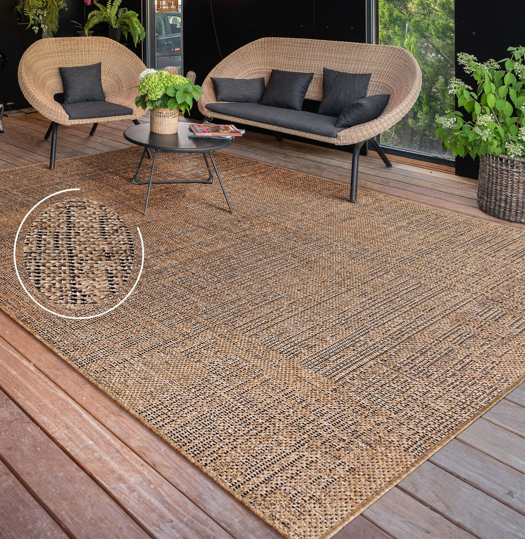 Rico mottled pattern indoor and outdoor rug featuring a brown and black weave on a wooden deck.