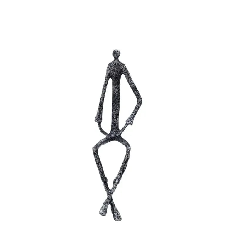 Large abstract sitting black metal sculpture of a stylized human figure with elongated limbs and textured surface