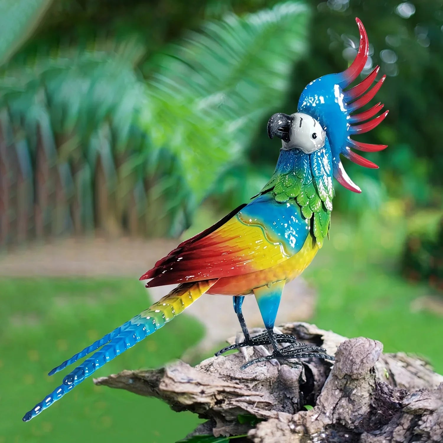 Vibrant multicolored metal parrot garden statue with blue crest and red tail feathers perched on a log.