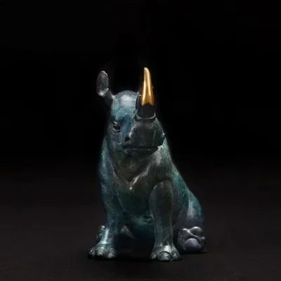 Luxury sitting rhinoceros animal figurine in antique green patina bronze with polished gold horn in poised stance