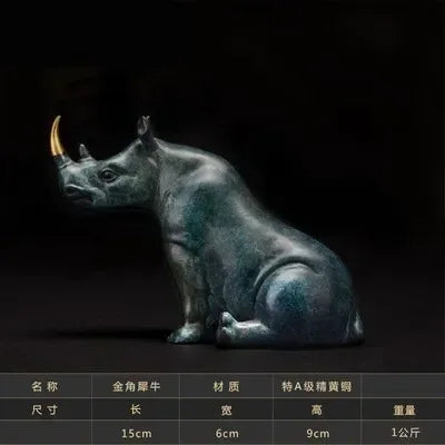 A sleek sitting rhinoceros animal figurine in antique green bronze with a polished metallic finish and golden horn