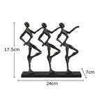 Black metallic metal sculpture of three stylized dancers on a rectangular base ideal for a unique metal desk display