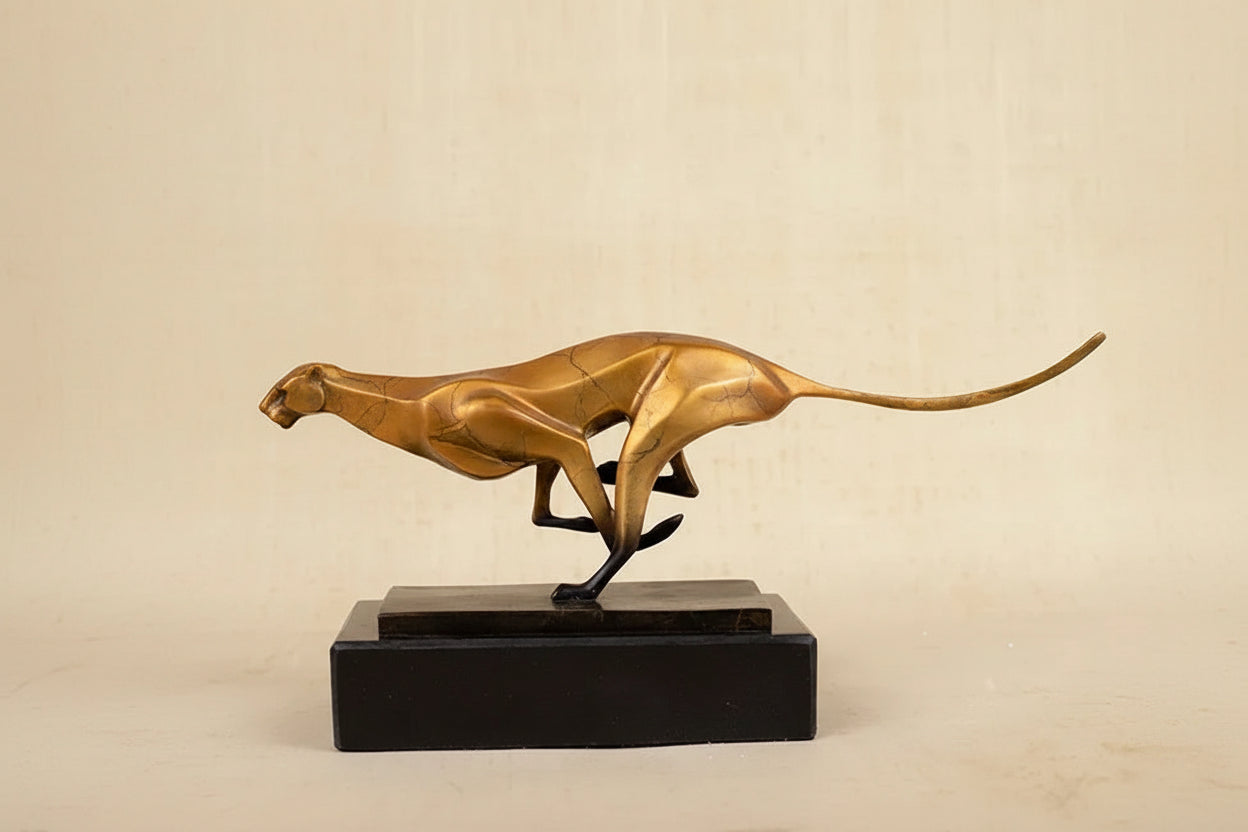 Golden cheetah sculpture with sleek design and polished metallic finish on black base for modern running leopard decor in living rooms