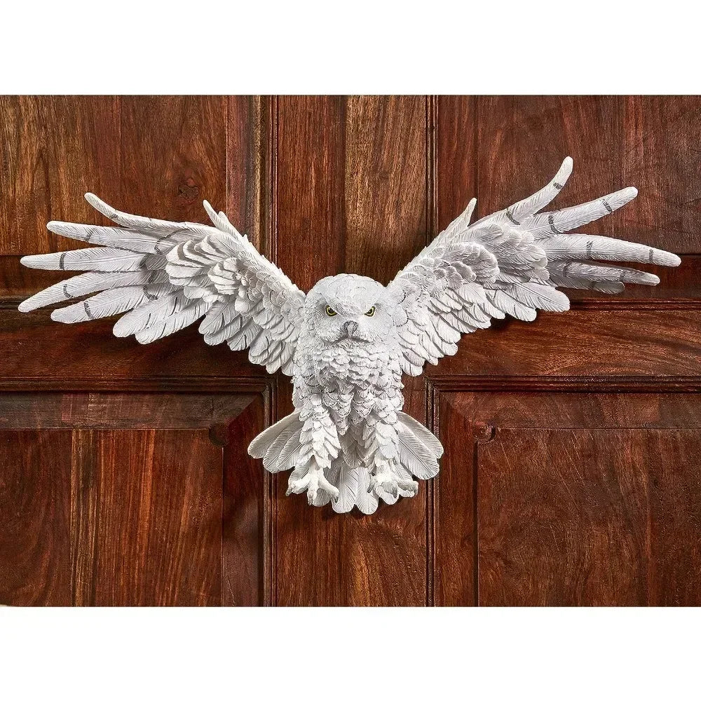 White owl sculpture wall decor in decorative metal with detailed feathered wings and textured body mounted on wooden door