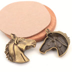 Two bronze horse head sculptures on a white background
