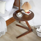 Dark brown compact wooden side table with round top and modern v-shaped base ideal for living room coffee table use