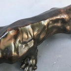Bronze-colored running leopard bronze sculpture with detailed musculature and textured surface for luxury decor