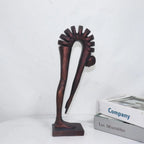 Decorative sculpture on a white surface with books in the background