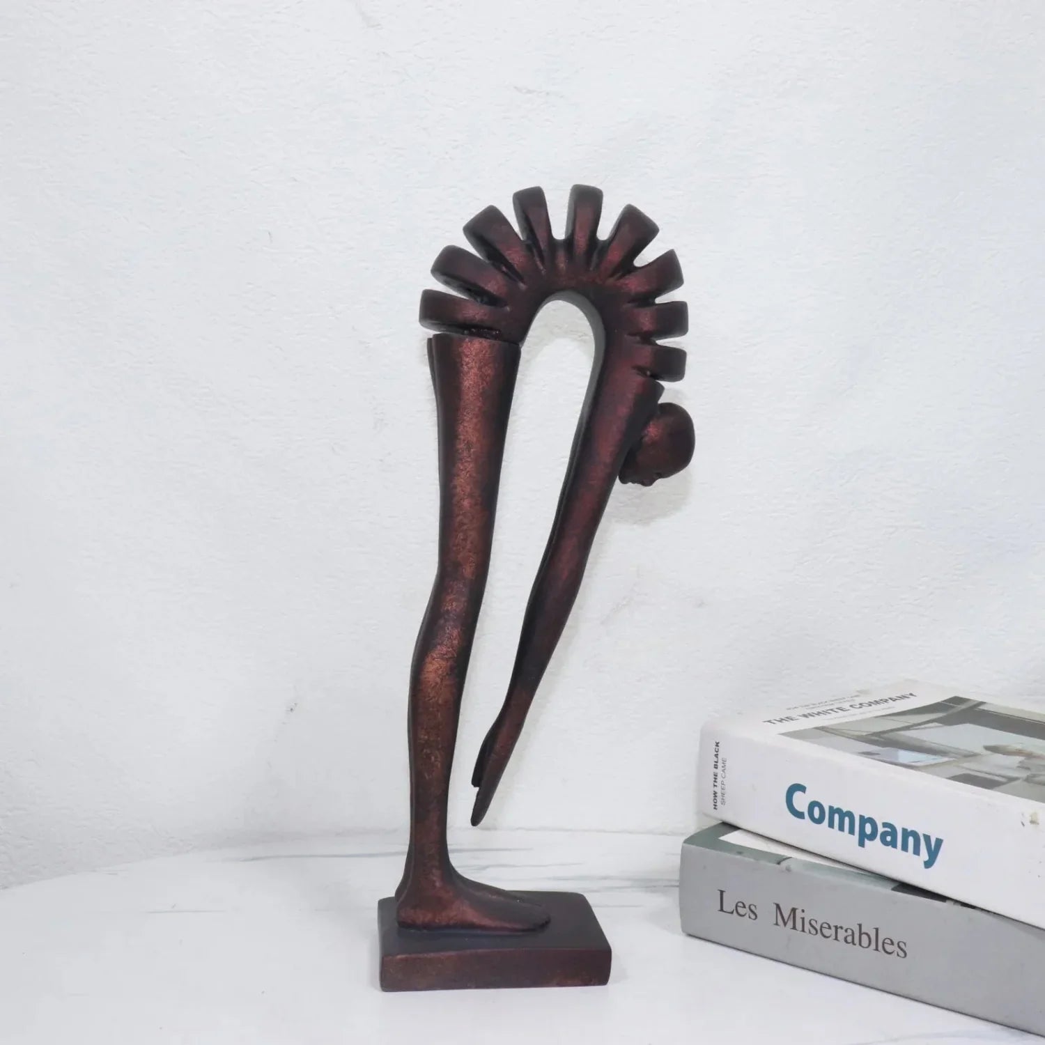 Decorative sculpture on a white surface with books in the background