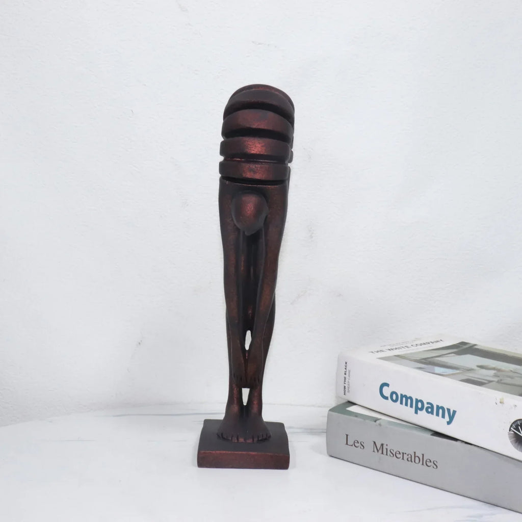 Decorative sculpture of a leg on a white surface with books in the background
