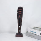 Decorative sculpture of a leg on a white surface with books in the background